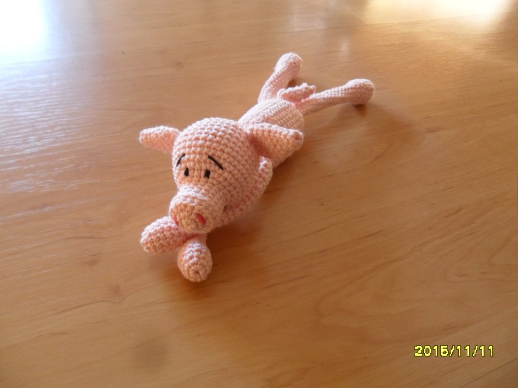 Nahaufnahme eines rosa Amigurumi‑Schweins mit sichtbaren Ohren und Schnauze.