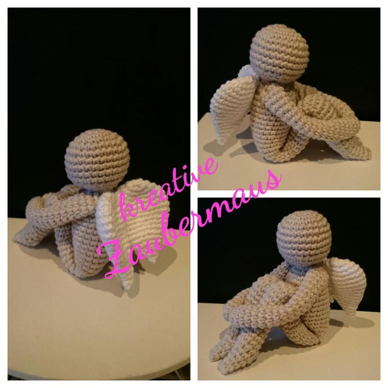 Beiges Amigurumi‑Engelchen mit weißen Flügeln, sitzend
