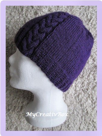 Violette gestrickte Mütze mit Zopfdetail auf Schaufensterkopf