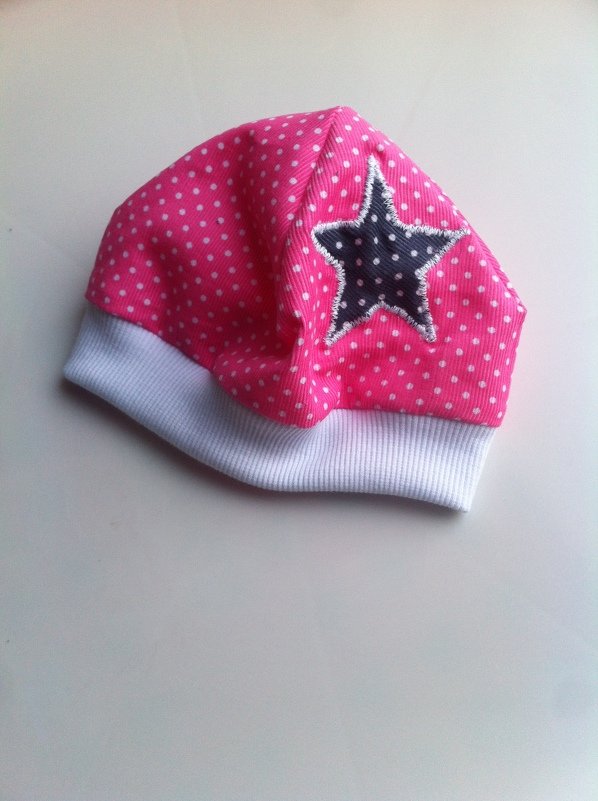 Rosa Kindermütze mit weißen Punkten, weißem Bündchen und dunkelblauem Stern