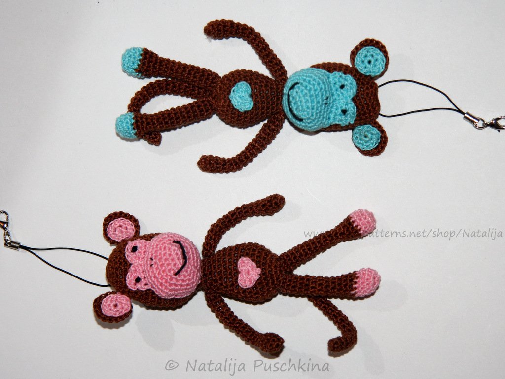 Zwei gehäkelte Amigurumi-Affen in Braun mit hellblauen bzw. rosa Details als Schlüsselanhänger