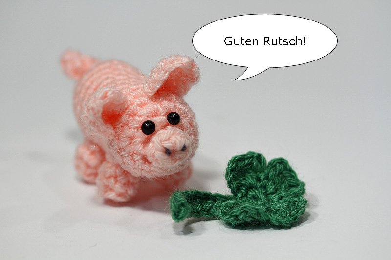 Rosa Amigurumi Glücksschwein mit Kleeblatt und Sprechblase 'Guten Rutsch!'