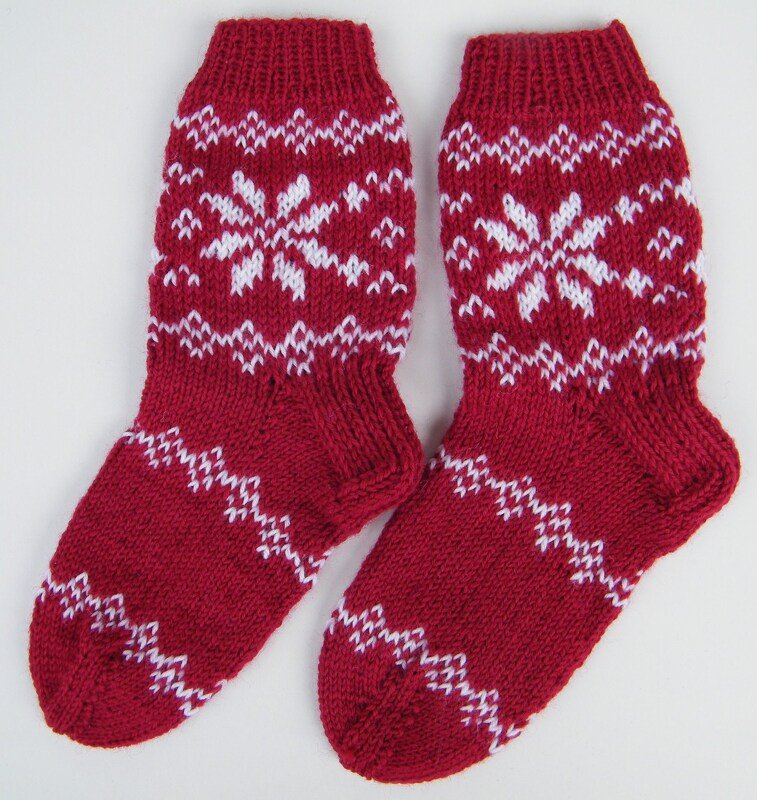 Paar rot-weiße Norwegerstrick-Socken mit Schneeflockenmotiv