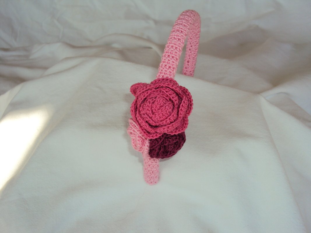 Handgefertigtes rosa Häkelstirnband mit seitlichen Rosen in Pink und Bordeaux