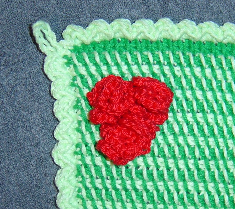Gehäkelter Topflappen in Grün und Hellgrün mit roter Blumen-Applikation und Aufhängeschlaufe