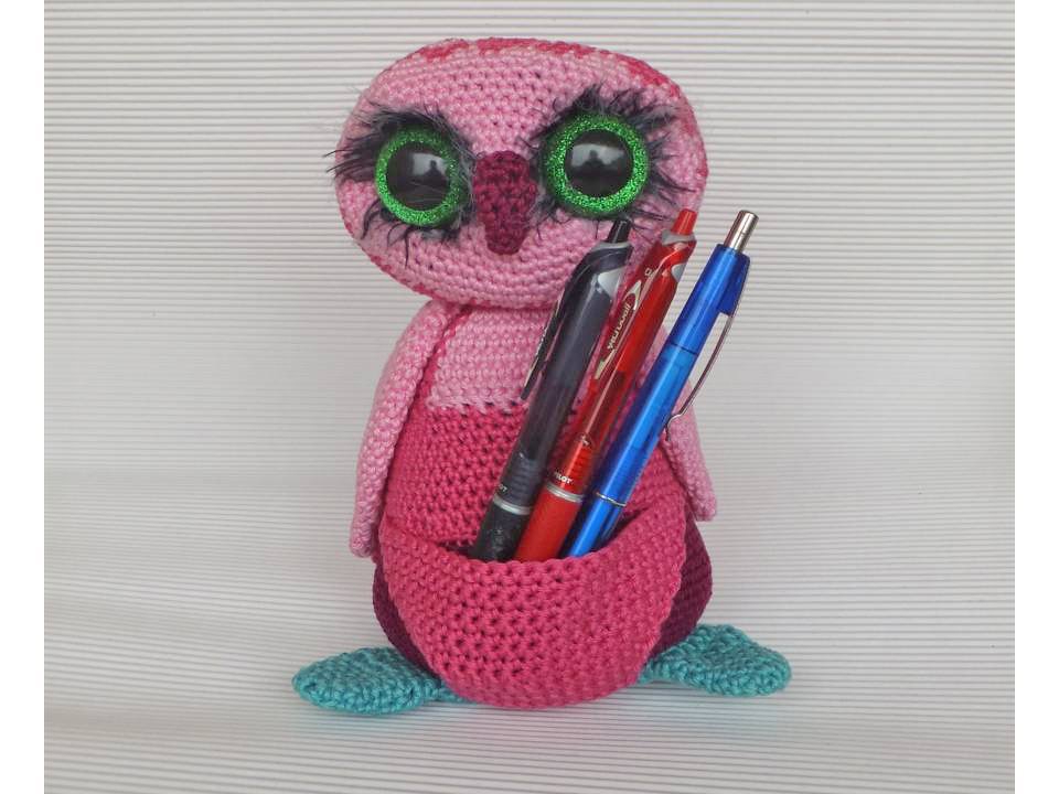 kompakte rosa gehäkelte Eule mit integriertem Vorderfach, gefüllt mit Stiften und grün glitzernden Augen