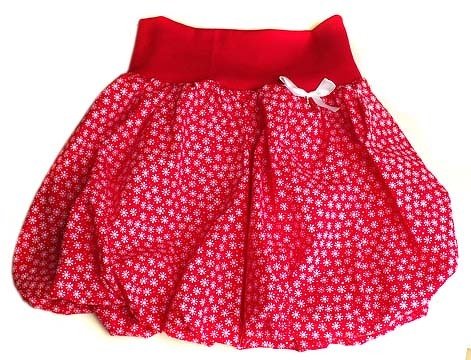Roter Kinder-Pumprock mit dichtem weißen Blütenmuster und weißer Schleife am Bund