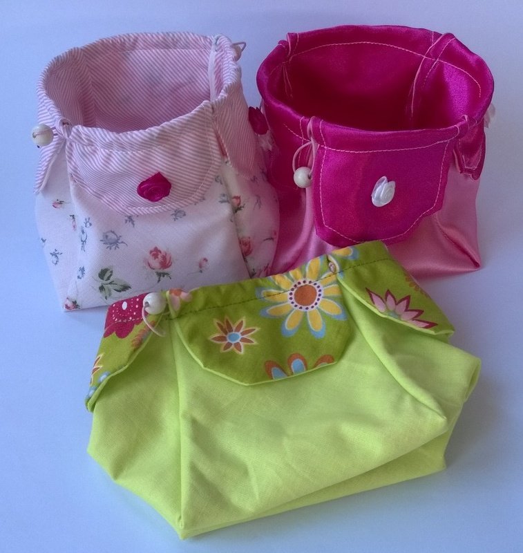 Drei Stoffkörbchen in Rosa, Pink und Hellgrün mit floralen Mustern und kleinen Klappen mit Perlen