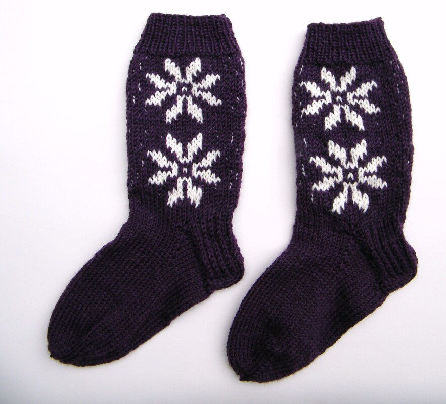 Dunkelviolette Stricksocken mit weißen Sternen und Rippbündchen