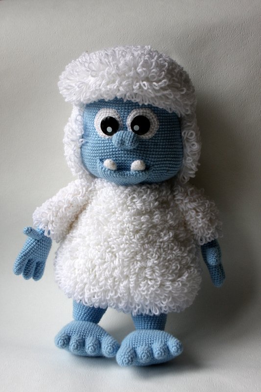 Nahaufnahme eines gehäkelten Amigurumi mit blauem Kopf und weißem Loopstich-Körper