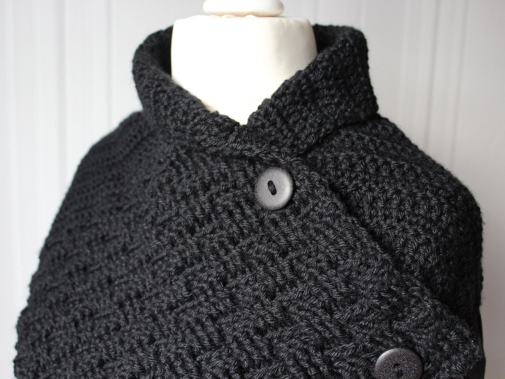 Black crocheted collar scarf with high collar and two dark buttons on a mannequin