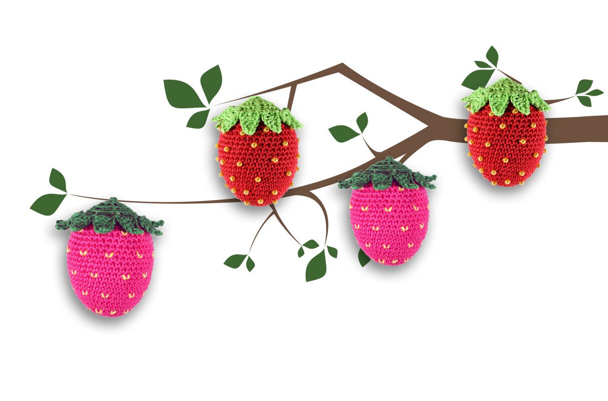 Vier gehäkelte Erdbeeren in Rot und Rosa mit grünen Blättern und Perlen, arrangiert an einem gezeichneten Ast