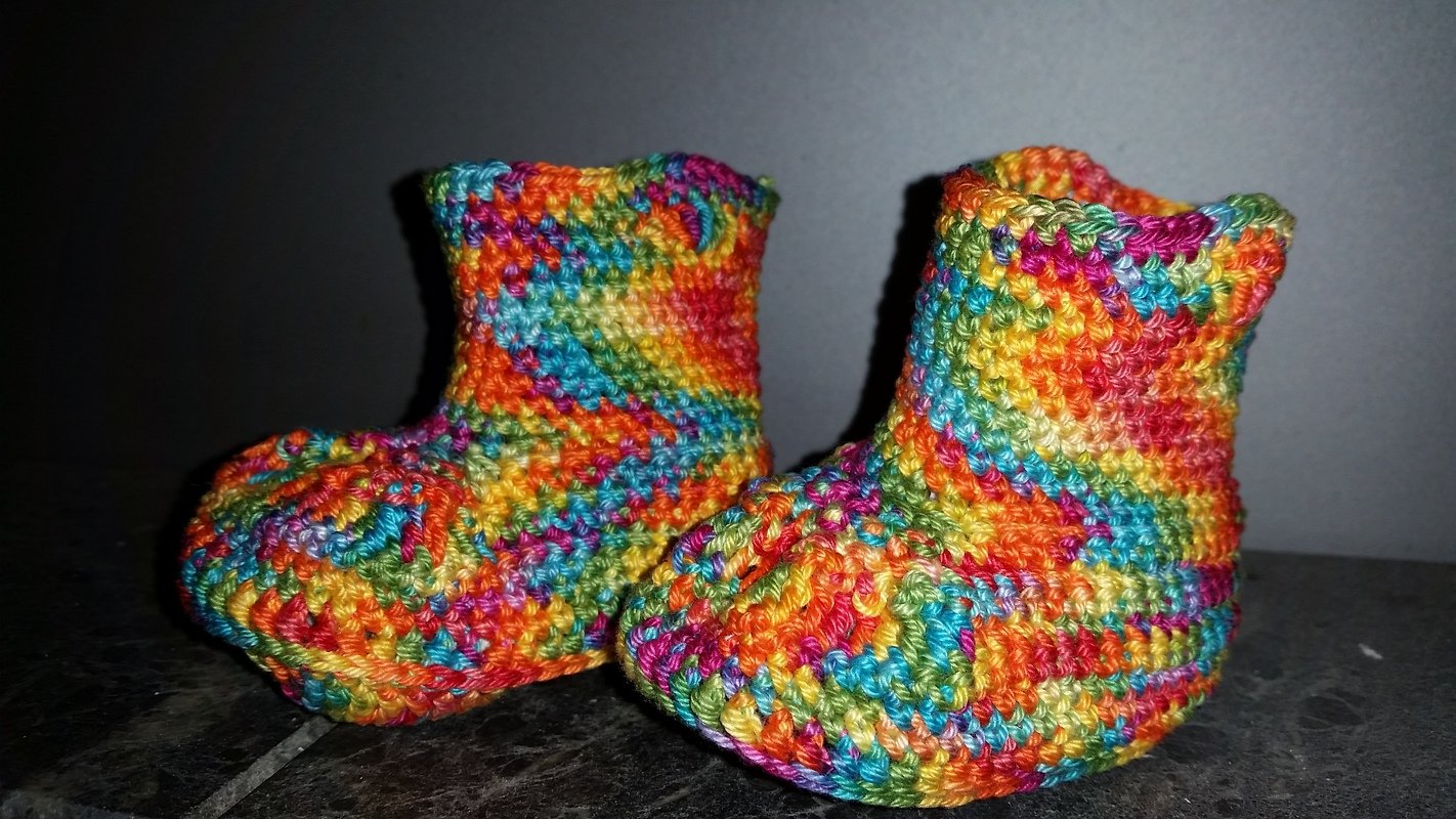 Paar bunter, gehäkelter Babyschuhe aus Farbverlaufsgarn