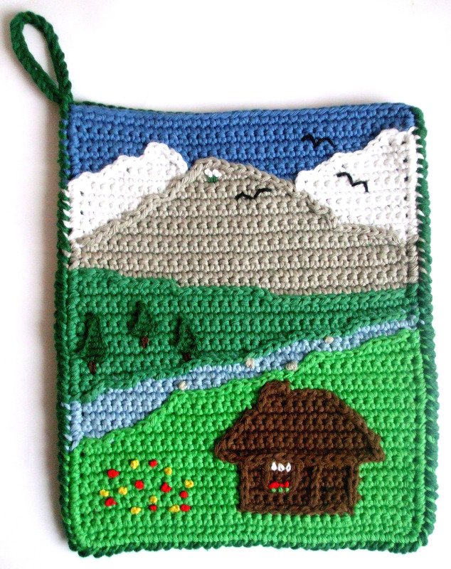 Quadratischer gehäkelter Topflappen mit Berg-, Fluss- und Häuschenmotiv und grüner Aufhängeschlaufe