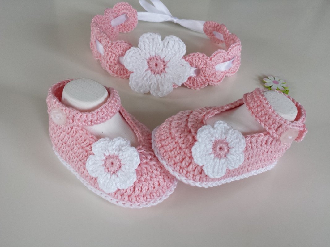 Pink crochet ballerina baby booties with white flower appliqués and matching ribbon headband