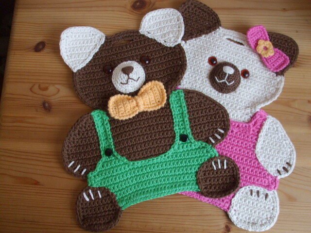 Zwei gehäkelte Teddybär-Topflappen, braun mit Latzhose und weiß mit Kleid