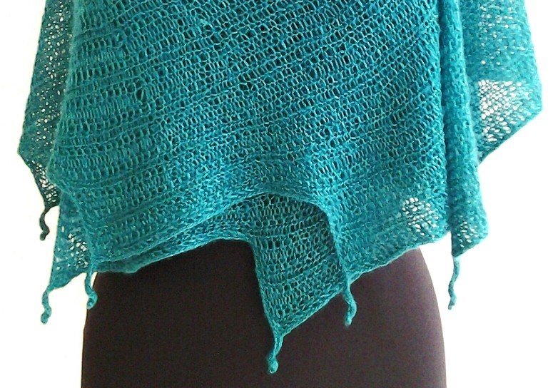 Türkises gestricktes Dreieckstuch mit Lochmuster und Picotkanten, auf dunklem Hintergrund drapiert