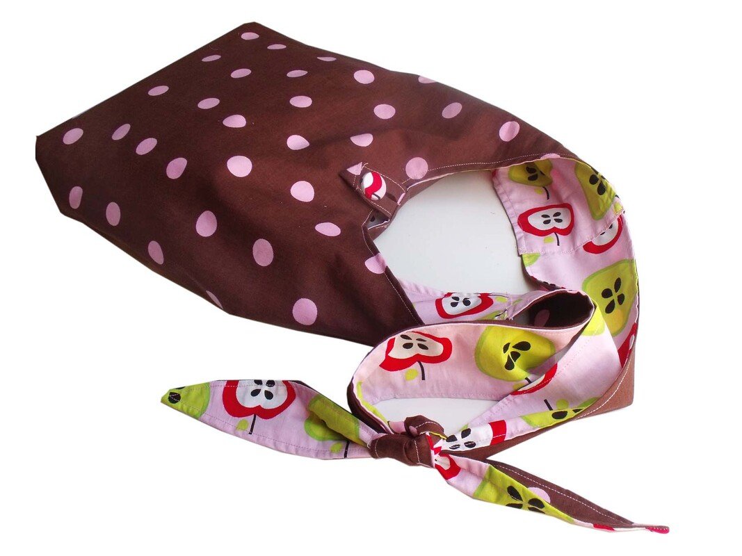 Wendbare Einkaufstasche, braun mit rosa Punkten außen und rosa Innenfutter mit Apfelmotiven, mit Schleifenverschluss