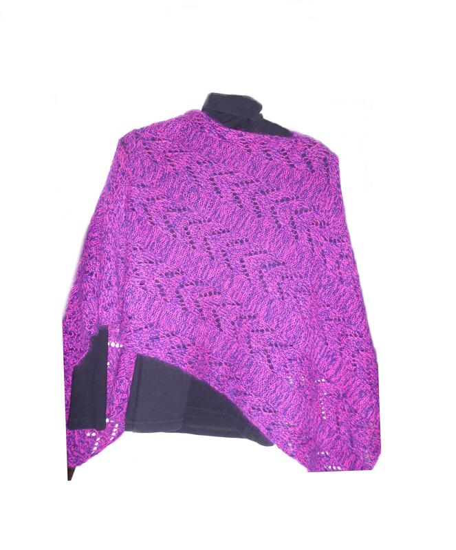 Asymmetrischer gestrickter Poncho in Magenta mit Zickzack-Lochmuster über dunklem Oberteil.