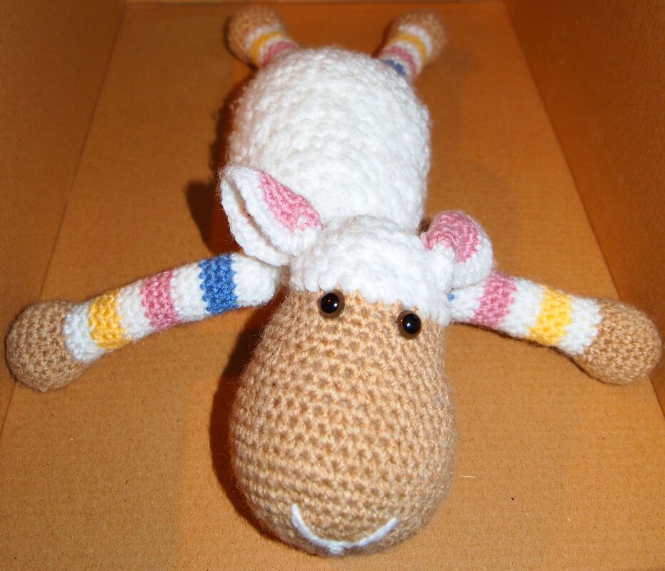 Gehäkeltes Schaf-Amigurumi mit weißem Körper und gestreiften Beinen