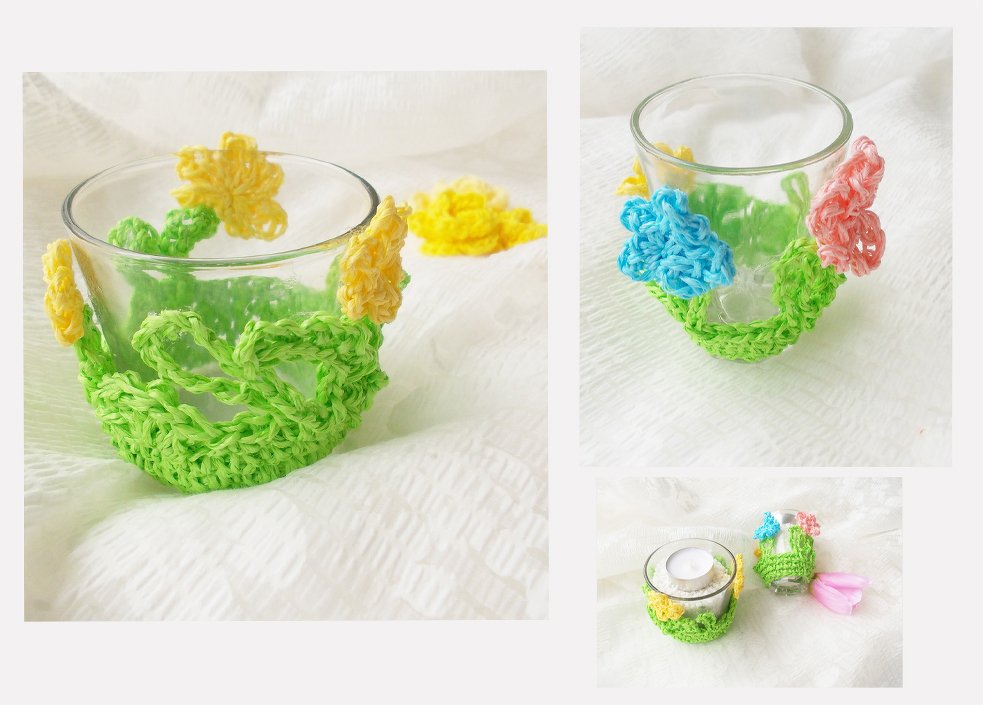 Zwei klare Gläser mit gehäkelten, grünen Blumenüberzügen, eines davon mit Teelicht