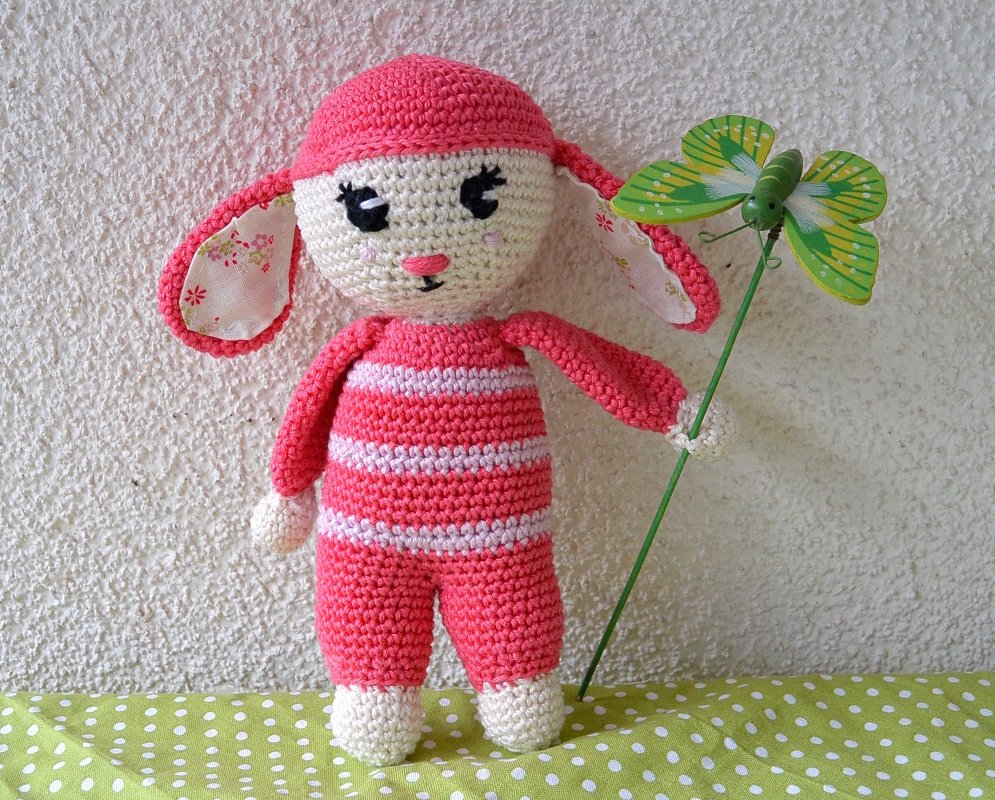 Gehäkeltes rosa-weiß gestreiftes Amigurumi-Häschen mit stoffgefütterten Ohren und grüner Schmetterlingsdeko
