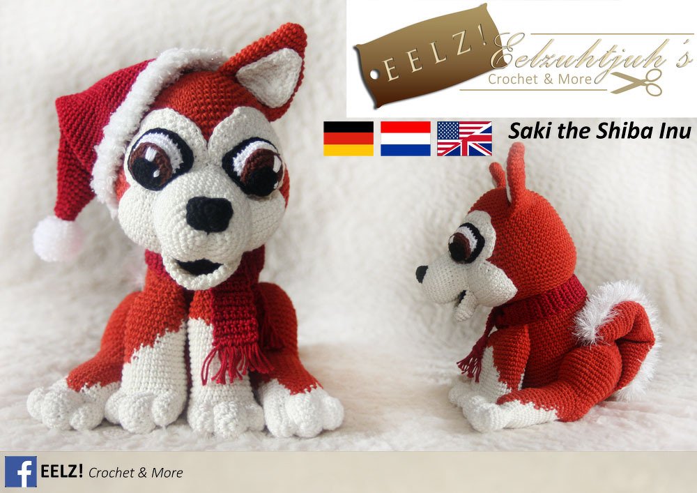 Zwei gehäkelte rot-weiße Shiba Inu-Amigurumi, eines mit Weihnachtsmütze und Schal