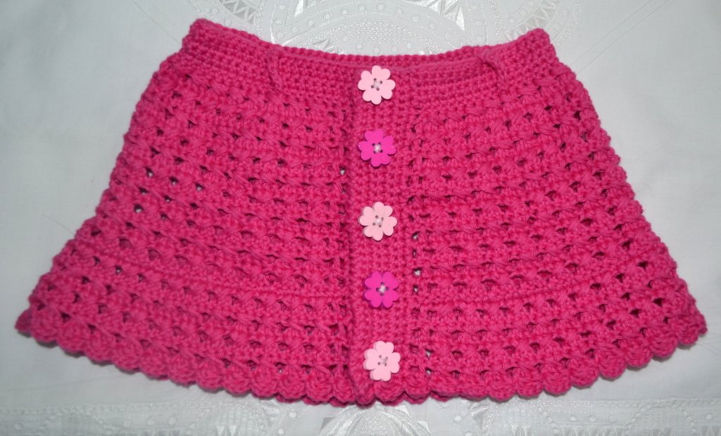 Gehäkelter Babyrock in Fuchsia mit Blumenknöpfen