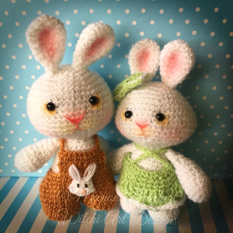 Zwei gehäkelte Osterhasen, einer mit grünem Kleid und Stirnband, der andere mit brauner Latzhose