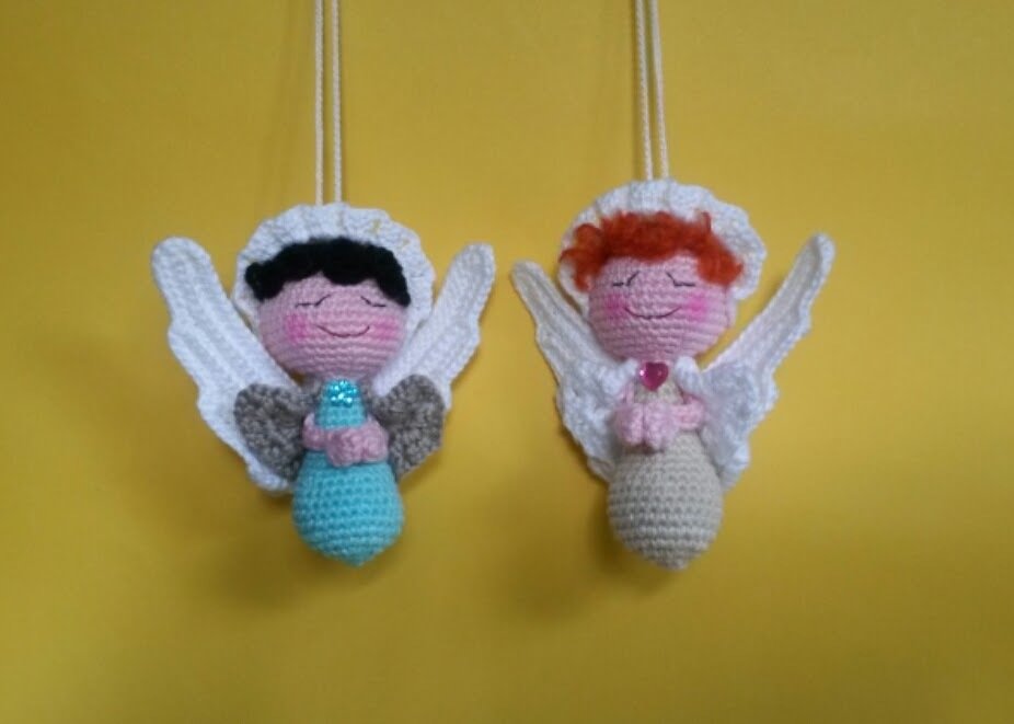 Zwei gehäkelte Amigurumi-Engel als Schlüsselanhänger vor gelbem Hintergrund