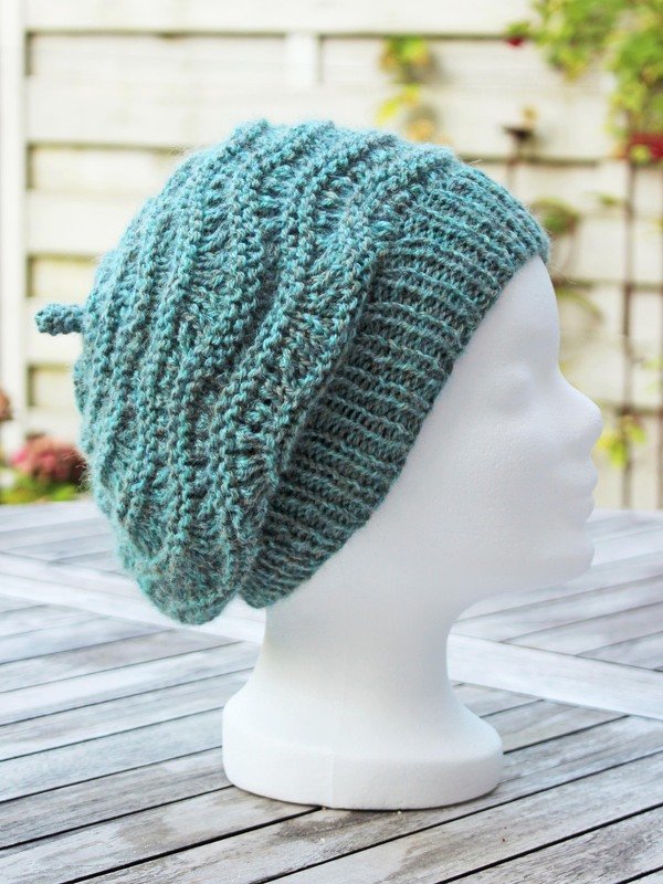 Teal textured knitted slouchy beanie on white mannequin head, side view