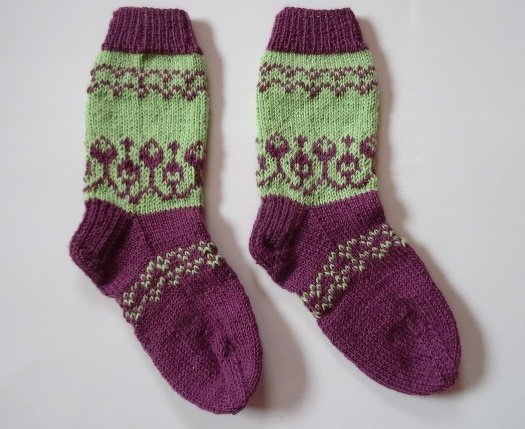 Gestricktes Paar Socken in Lila und Hellgrün mit dekorativen Mustern an Schaft und Fuß
