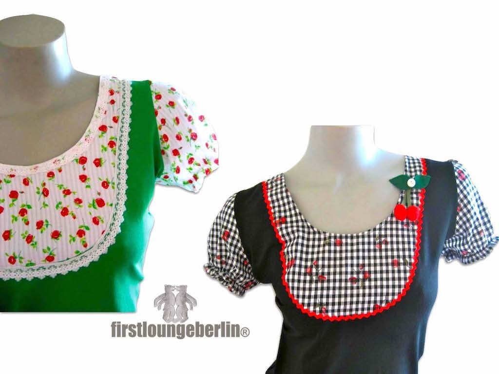 Zwei Trachtenblusen: grüne Bluse mit Rosenmuster und Spitze; schwarze Bluse mit Vichy-Karo und Kirsch-Applikation