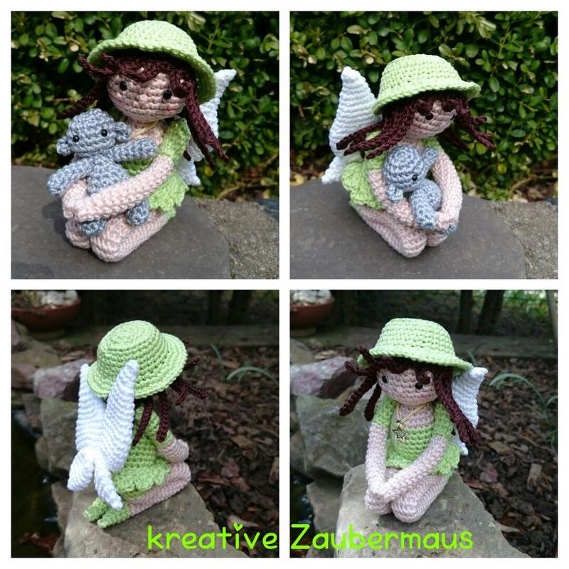 Gehäkelte Amigurumi-Fee in Hellgrün mit Hut und weißen Flügeln, die einen kleinen grauen Teddybären hält.