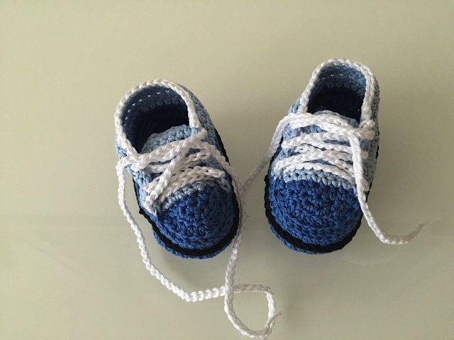 Gehäkelte Babyschuhe in Blau und Weiß im Sneaker-Stil mit weißen Schnürbändern