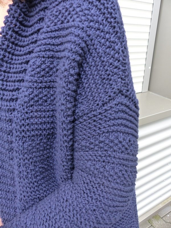 Detailansicht Maschenstruktur einer dunkelblauen grob gestrickten Jacke