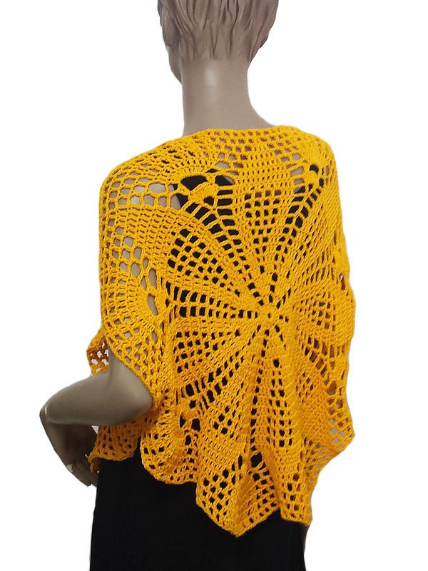 Rückenansicht eines leuchtend gelben gehäkelten Ponchos mit sonnenblütenähnlichem Zentralmotiv