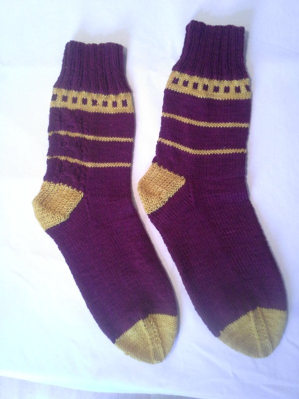 Paar gestrickter Herrensocken in Pflaume und Senfgelb mit Muster am Bündchen.