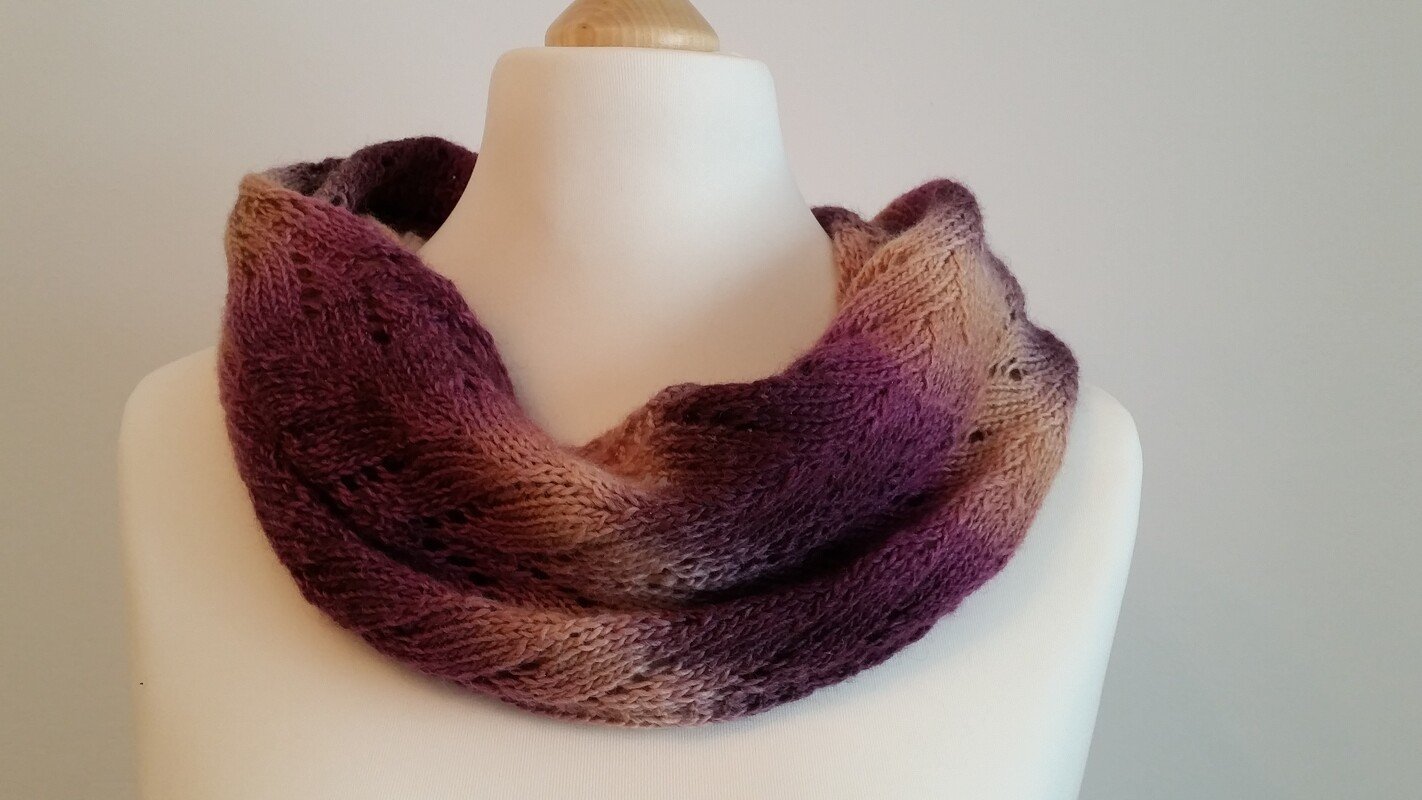 rundgestrickter Loop in Violett- und Beigetönen auf einer Schaufensterpuppe