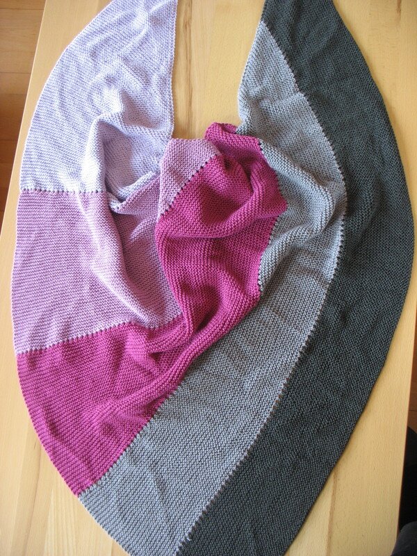 Flach ausgebreitetes Dreieckstuch mit Blockstreifen in Pink, Rosa und Grau, kraus rechts gestrickt
