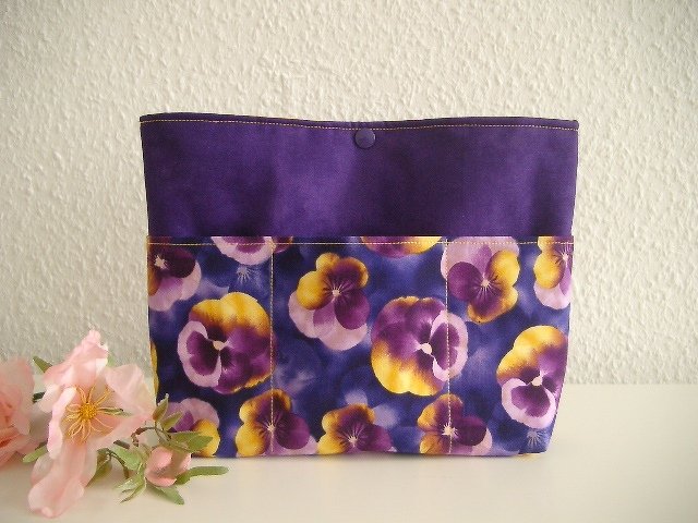 Dunkellila Stoffutensilo mit violett-gelbem Stiefmütterchen-Motiv und sichtbaren Außentaschen