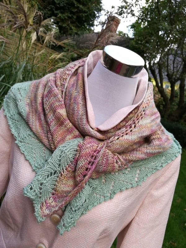 Pastellfarbenes Dreieckstuch mit mintgrünem Spitzenrand auf einer Schaufensterpuppe