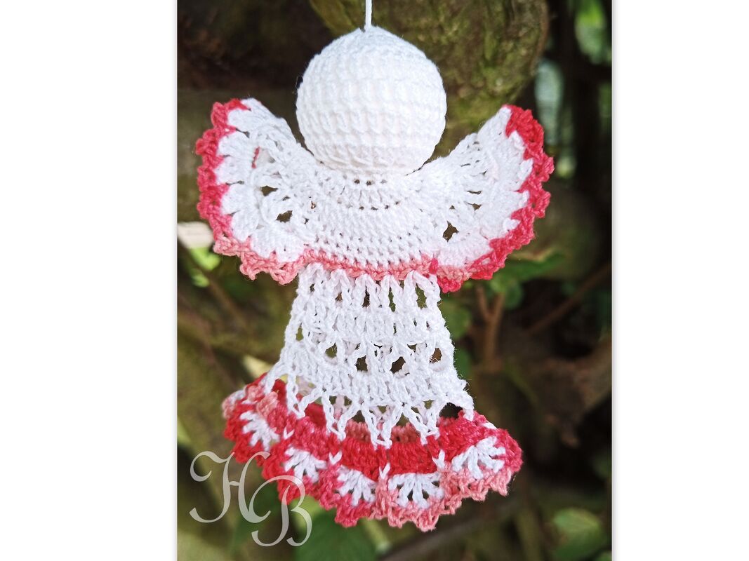 Gehäkelter Weihnachtsengel in Weiß mit rosa Rand, hängend an Schlaufe