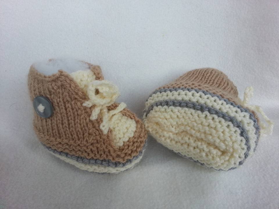 Zweifarbige gestrickte Babyschuhe mit gestreifter Sohle, Zierschnürung und Knopf