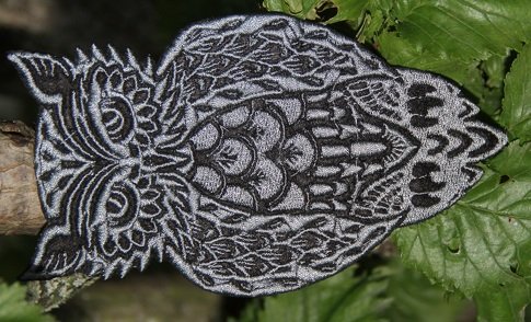 Gestickte ornamentale Eule in Schwarz und Grau auf Laub