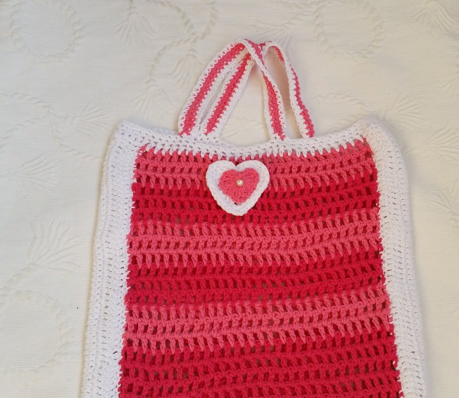 Gehäkelte Tasche in Pink- und Weißtönen mit Herzapplikation