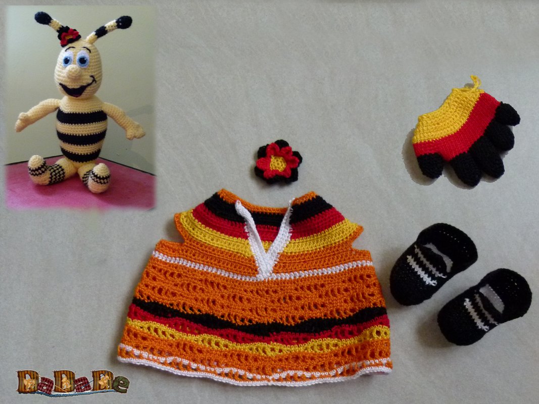 Gehäkelte Biene (Amigurumi), ärmelloses Baby-Oberteil, Babyschühchen, Handschuh und Zierblüte in Schwarz, Rot, Orange, Gelb und Weiß.