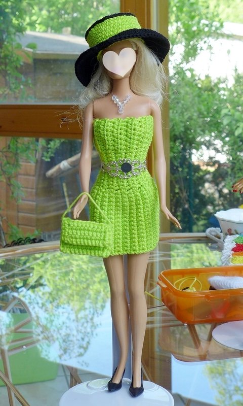 Puppe mit gehäkeltem limettengrünen trägerlosen Kleid, Hut mit schwarzer Krempe, passender Handtasche, Gürtel und Halskette.