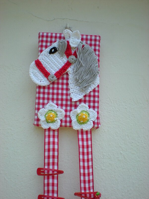 Häkel-Pferdekopf auf kariertem Stoffpanel mit Haarklammer-Bändern und Häkelblüten