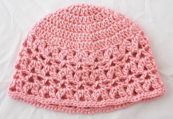 Rosa Häkel-Babymütze mit offenem Muster und geschlossenem Oberteil